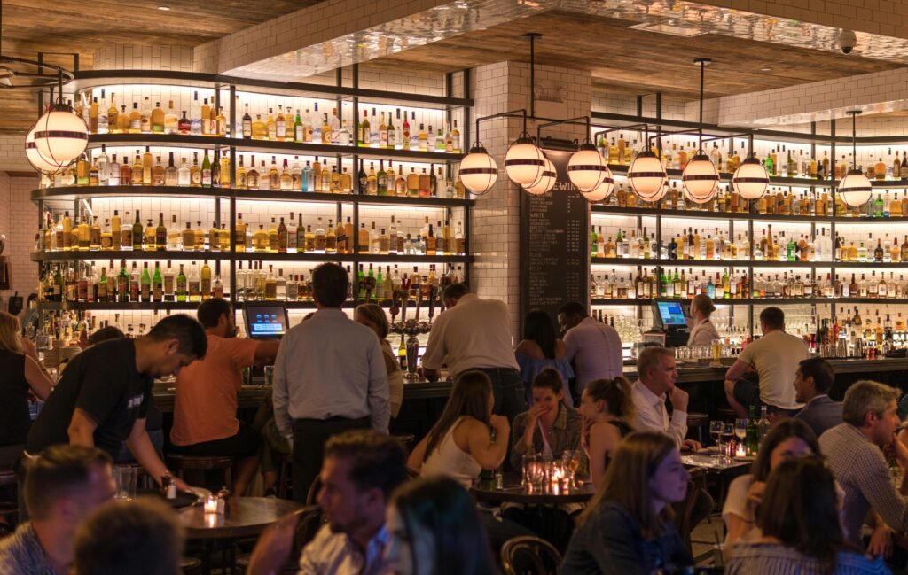 inside a busy and cramped restaurant with a tall wine rack at night