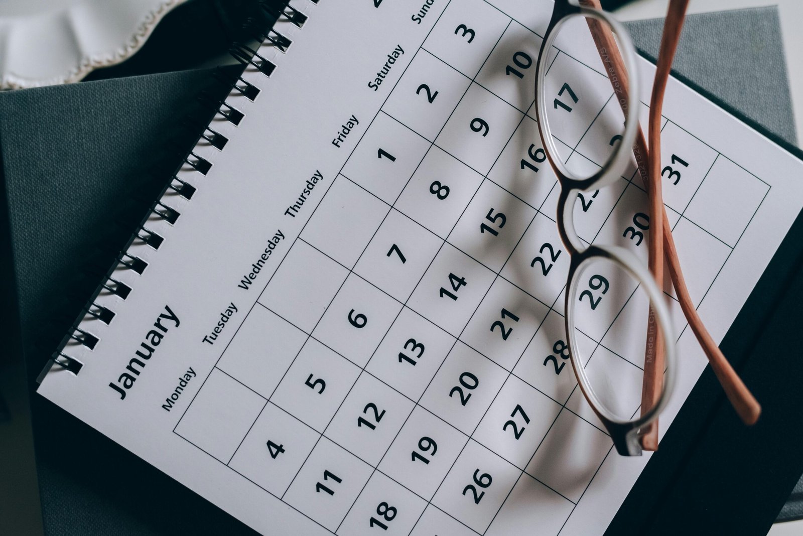 a calendar and a pair of eyeglasses on top of it