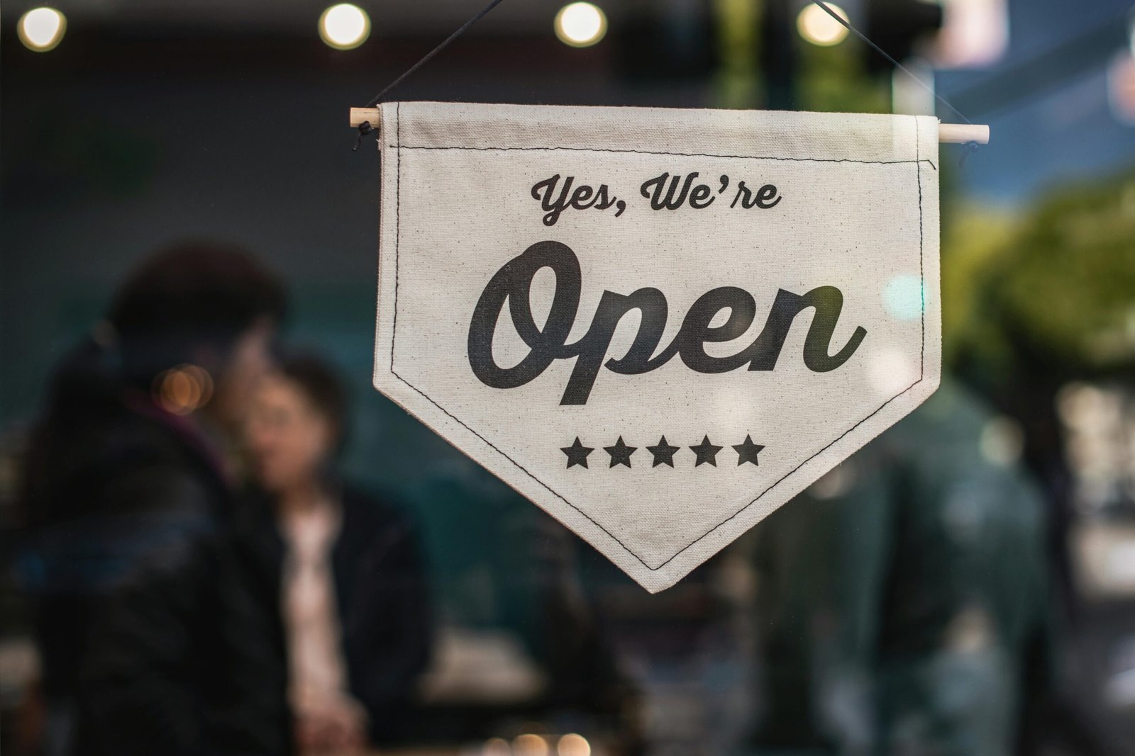 a close up of a business' glass door and "we're open" as door sign