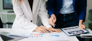 UK SME owner reviewing asset finance options on a laptop, with office background